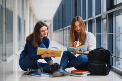 Two students reading from books. 